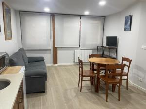 a living room with a couch and a table and chairs at erdiko kalea 9 in Marquina-Jemein