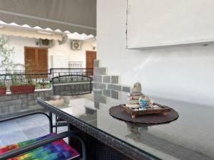 a table with a statue on top of a balcony at Veranda Apartment Paralia Ofriniou in Ofrínion