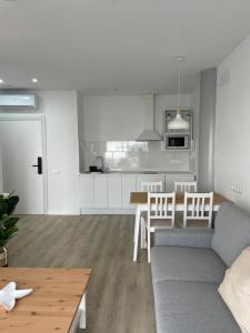 a living room and kitchen with a couch and a table at Island Home Fuerteventura in Corralejo