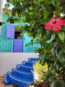 a group of blue stairs with a red flower at Chalé Flor do Ser in Canoa Quebrada