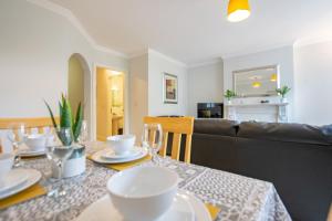 a dining room with a table and a couch at 131 - Spacious 2 Bed Apt with Parking in Galway