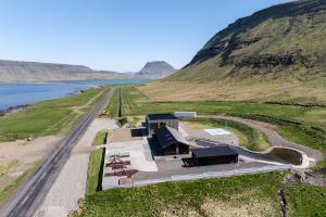 eine Luftansicht eines Gebäudes auf einem Hügel neben einer Straße in der Unterkunft Búlandshöfði family paradise in Grundarfjörður