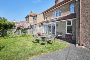 a table and chairs in the yard of a house at Host & Stay - Chirnells in Bamburgh +21 photos