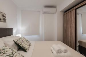a bedroom with a bed with towels on it at Phaedrus Living Skiathos Luxury Residences Blu in Skiathos Town +3 photos