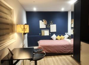 a blue bedroom with a bed and a table at Double bed Studio in Finchley,North London in Finchley