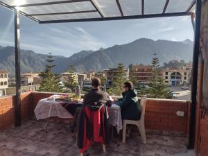 a man and woman sitting at a table on a balcony at La Terraza de Huaruro in Cabanaconde +3 photos