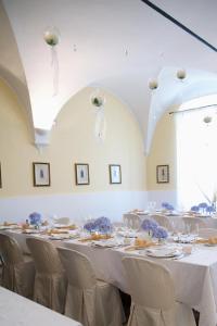 una habitación con mesas blancas y sillas con flores azules. en Il Convento, en Trino