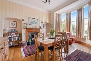 a dining room with a table and a fireplace at Gruinard Guest House in Beauly