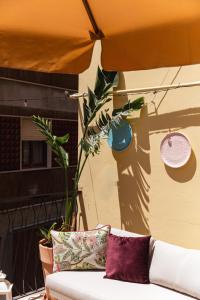 Un sofá sentado bajo una sombrilla en un patio. en Mariannina Apartments - Maiori, en Maiori