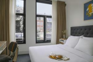 a hotel room with a white bed and windows at Park House Hotel Museum Quarter, Sonder by Marriott Bonvoy in Amsterdam +28 photos