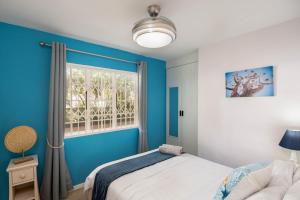 a blue bedroom with a bed and a window at Villa Med 14 in Ballito