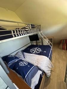 a bedroom with two bunk beds with blue and white pillows at Bord de Mer in Berneval-le-Grand