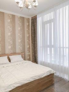 ein Schlafzimmer mit einem Bett und einem großen Fenster in der Unterkunft Apartment Tuska in Žabljak