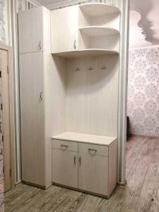 eine Küche mit einem Regal und einem weißen Schrank in der Unterkunft Apartment Tuska in Žabljak + 1 Foto