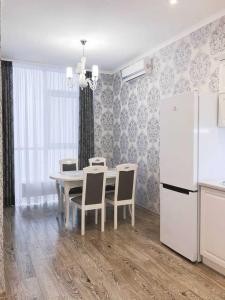 eine Küche mit Tisch und Stühlen und einem Kühlschrank in der Unterkunft Apartment Tuska in Žabljak