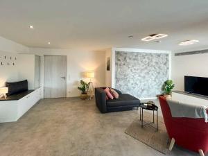 a living room with a couch and a television at Hotel und Ferienwohnungen Nebauer in Frontenhausen