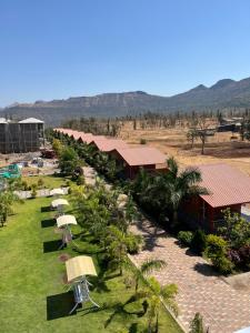 an aerial view of a resort with umbrellas on a lawn at Daksh The Valley Resort - Saputara in Saputara
