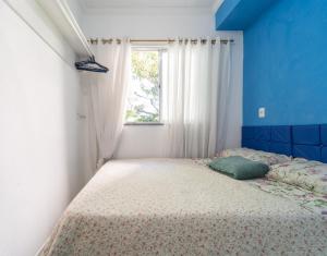 un dormitorio con una cama y una ventana en Apto com Wi-Fi a 950m da Praia da Tartaruga, en Rio das Ostras