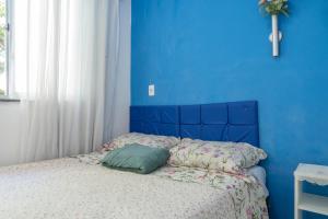 Un dormitorio azul con una cama con una pared azul. en Apto com Wi-Fi a 950m da Praia da Tartaruga, en Rio das Ostras