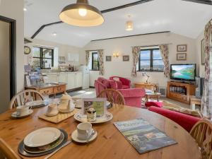 a kitchen and living room with a wooden table at Dairy Cottage Dulverton in Dulverton