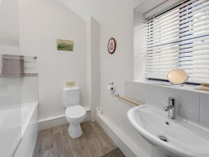 a white bathroom with a toilet and a sink at Dairy Cottage Dulverton in Dulverton +39 photos