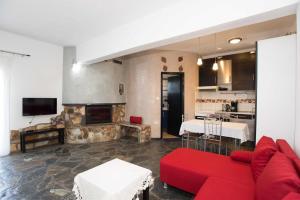 a living room with a red couch and a kitchen at PAROS APARTMENT MELAS a2 in Parikia