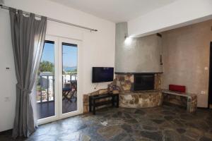 a living room with a stone fireplace and a television at PAROS APARTMENT MELAS a2 in Parikia