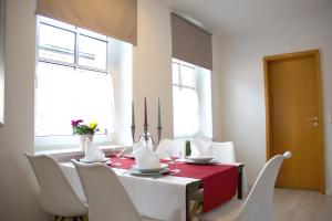 una sala da pranzo con tavolo rosso e sedie bianche di Loftartiges Appartment in Magdeburg, 2 Schlafzimmer, Küche und Bad - B a Magdeburgo Altre 10 foto