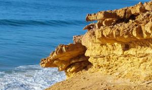een rotsachtige klif naast de oceaan bij Casa Calma in Salema +17 foto's