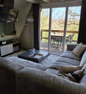 una sala de estar con un sofá y una mesa en bungalow 199 durbuy, en Durbuy