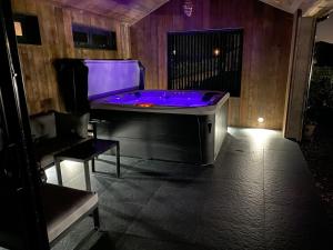 ブラックプールにあるWayside Lodgeの紫色の照明が付くジャグジータブが備わる客室です。