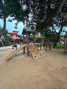 a wooden playground with a slide in a park at Casa Quinta do Atlântico - Aconchego da Paz 150m da praia in Búzios