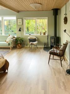 un soggiorno con pavimento in legno e 2 finestre di The Peaceful Haven Near Liseleje a Hundested