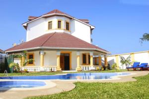 a house with a pool in front of it at Greenfield Villa D- Diani in Kwale