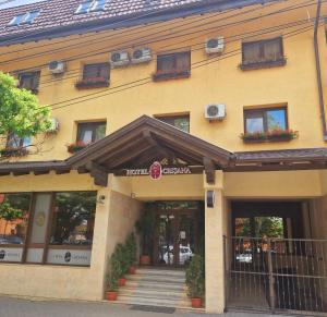 阿拉德克瑞萨纳阿拉德酒店的一栋黄色的建筑,前面有窗户和楼梯