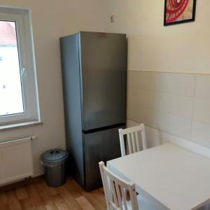 a stainless steel refrigerator in a kitchen with a table at Leuna - Kurzzeitvermietungen direkt bei den Leunawerken, 2-3 Schlafzimmer in Leuna