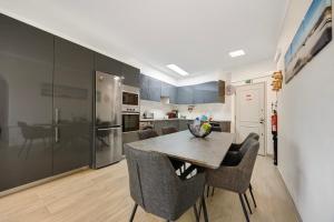 a kitchen with a dining room table and chairs at Apartamento Praia da Rocha in Portimão +16 photos