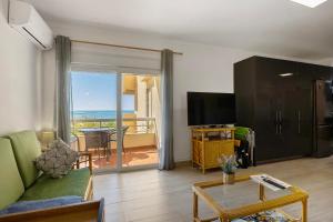 a living room with a green couch and a television at Apartamento Praia da Rocha in Portimão