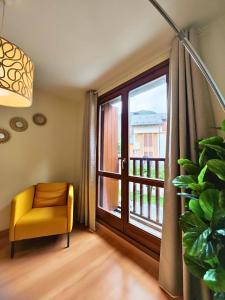 a yellow chair in a room with a window at Apartamento Punta Escarra in Escarrilla