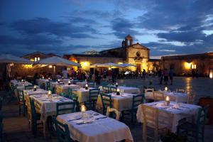 a group of tables with white tablecloths and candles at Casa Alba Marina in Marzamemi