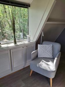 a chair sitting in a room with a window at bungalow 199 durbuy in Durbuy