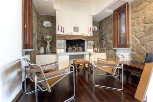 Una sala de estar con mesa y sillas y una chimenea. en Villa Ballodole, en Florencia