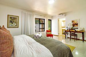 a bedroom with a bed and a desk in it at 5 Rembrandt Guesthouse in Somerset West +186 photos