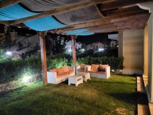 eine Terrasse mit Sofas auf dem Rasen bei Nacht in der Unterkunft Town house Raselhakma north coast egypt in Ras Elhekma
