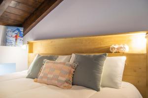 a bed with white pillows and a wooden headboard at Cal badia in Vilallovent