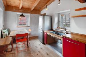 カンピテッロ・ディ・ファッサにあるDolomites Chalet Pianのテーブルと冷蔵庫のあるキッチン
