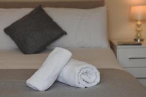 a white towel sitting on top of a bed at Dartside 4 in Dartmouth