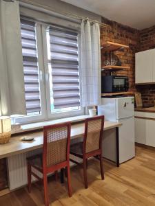 a kitchen with a table and chairs and windows at Apartament Szadoka - Katowice, Free Parking in Katowice