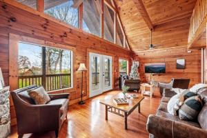 a living room with wooden walls and a large window at Blue Ridge Retreat in Pigeon Forge