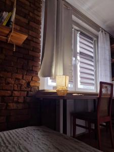 a bedroom with a table and a window with a lamp at Apartament Szadoka - Katowice, Free Parking in Katowice